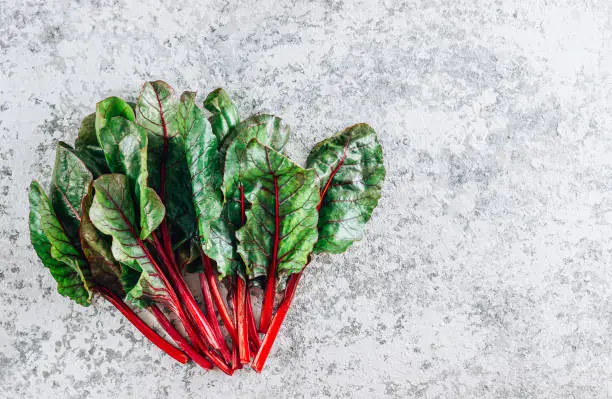 Mangold salad, Fresh raw leaves of chard on a stone background. Top view with copy space