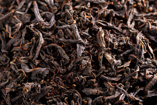 dry black large leaf tea. background, texture - friable imagens e fotografias de stock