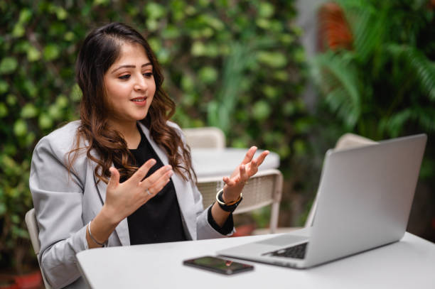 Young female professional taking video conference using laptop.