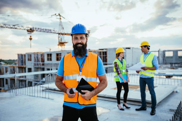 istock Portrait of smiling construction engineers with protective helmets and reflective wests 1366394098