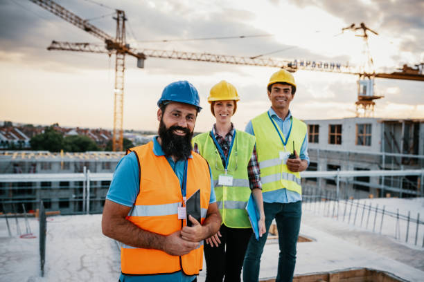 istock Portrait of smiling construction engineers with protective helmets and reflective wests 1366394186