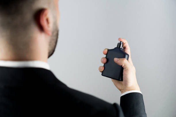 istock Unrecognizable young man applying cologne spray. 1366395220