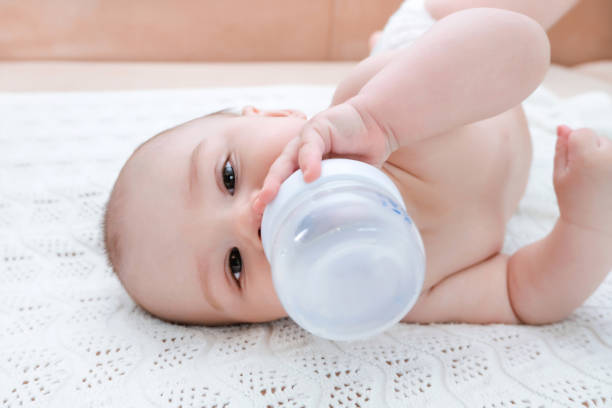 istock Baby is lying on its side and drinks water or milk 1366396548