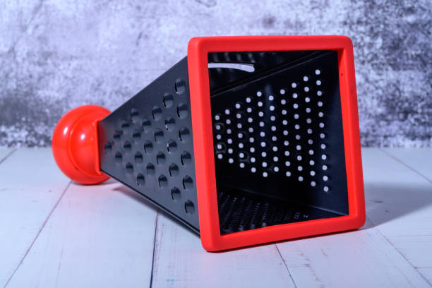 istock Grater for vegetables on a background of light marble. Kitchen grater. 1366397961