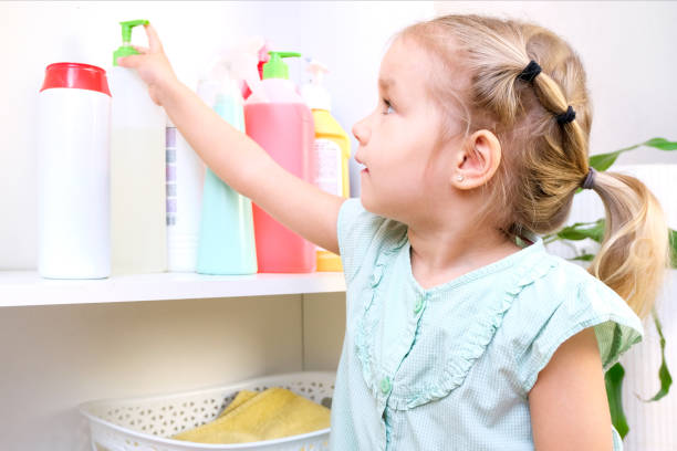 Toddler touches bottles of household chemicals, household cleaning products. Toddler touches bottles of household chemicals, household cleaning products. Dangerous situation poisonous stock pictures, royalty-free photos & images