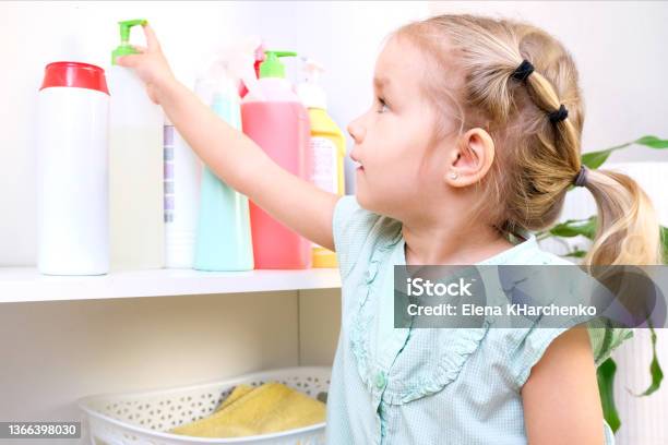 Toddler Touches Bottles Of Household Chemicals Household Cleaning Products Stock Photo - Download Image Now