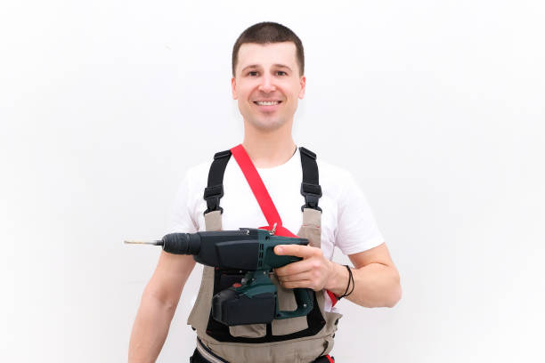 istock worker has a hammer drill and a screwdriver in his hands. 1366398037