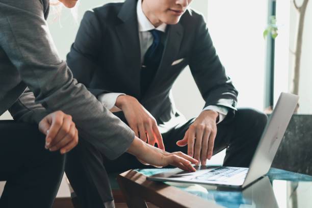 Two diverse ethnicity business people discussing in a conference room.