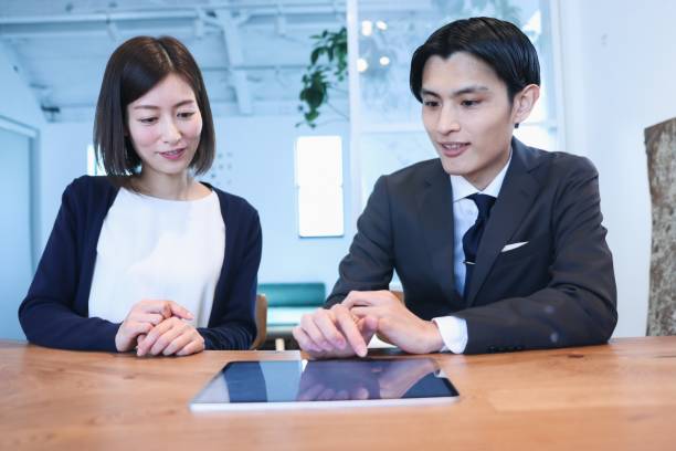 istock Two people discussing in a conference room. 1366399317