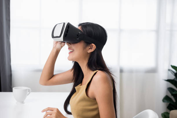 istock Young asian woman put on vr glasses into virtual simulated world. Future technology digital cyber universe. Person Enjoying an Experiences of Virtual World. 1366400506