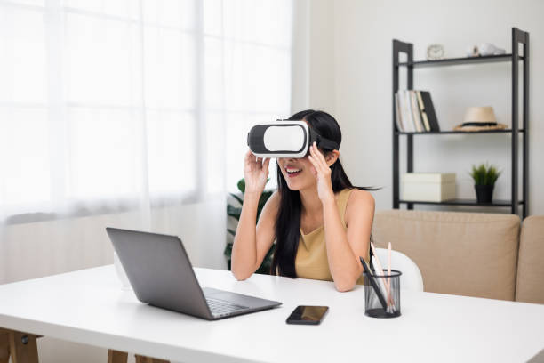 istock Young asian woman put on vr glasses into virtual simulated world. Future technology digital cyber universe. Person Enjoying an Experiences of Virtual World. 1366400507