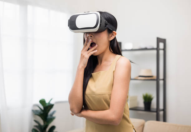 istock Young asian woman put on vr glasses into virtual simulated world. Future technology digital cyber universe. Person Enjoying an Experiences of Virtual World. 1366400533