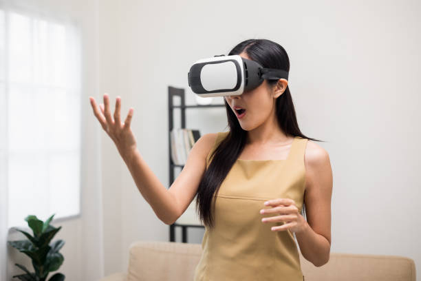 istock Young asian woman put on vr glasses into virtual simulated world. Future technology digital cyber universe. Person Enjoying an Experiences of Virtual World. 1366400710