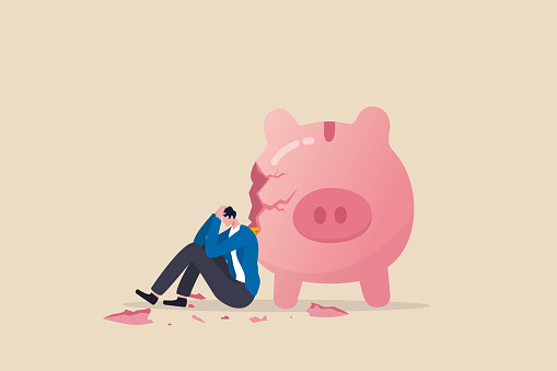 Debt and loan problem, financial mistake, povety or bankruptcy concept, depressed businessman sitting with broken piggy bank.