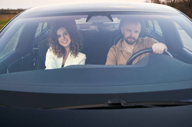 istock Two people riding in car and looking around. 1366403348