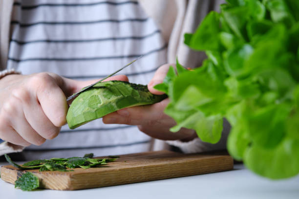 istock Human hands are preparing raw salad with lettuce, celery stalks, green apple, oranges and avocado 1366404585