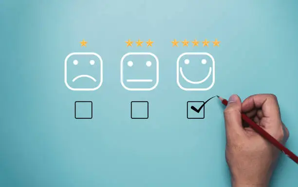 Photo of Hand tick or check mark to select smile face with five stars on blue background , Customer and client  evaluation after use product and service concept.