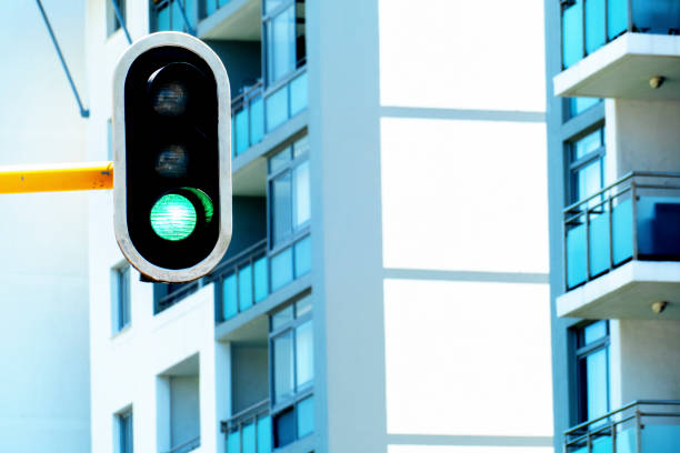 Green light signal on robots, traffic lights, in city with buildings out of focus in the background