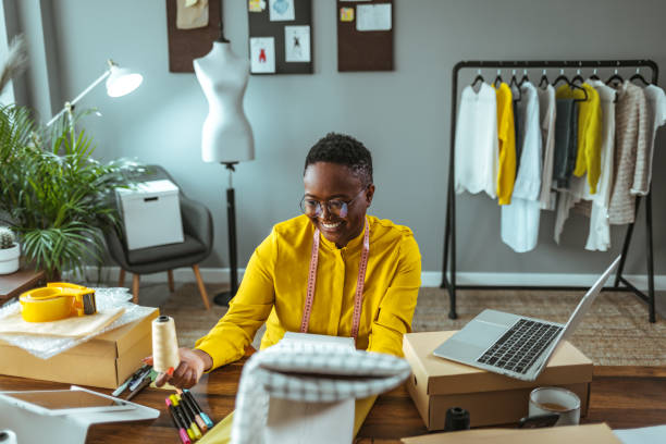 istock Checking online sales. Young woman tailor with laptop 1366407779