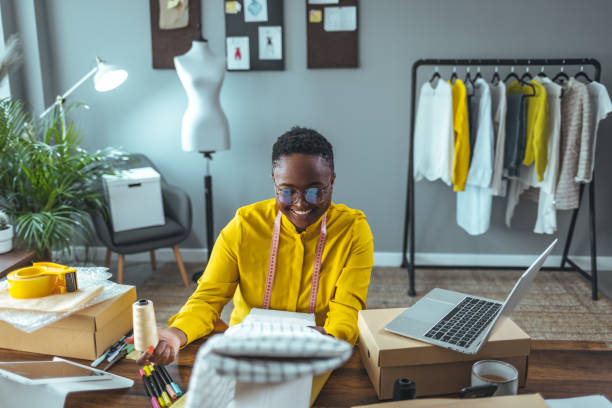 istock Checking online sales. Young woman tailor with laptop 1366409475