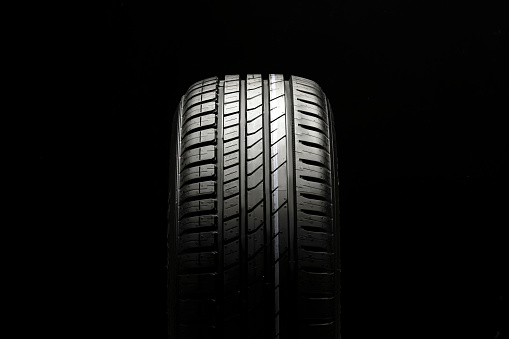 beautiful new summer tire on a black background. summer protector against aquaplaning and fuel economy.