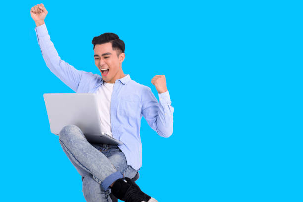 istock Excited young man dressed casual  and working with laptop 1366410198