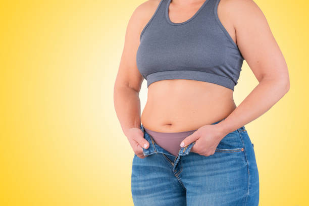 istock Woman in jeans showing abdominal fat 1366410453
