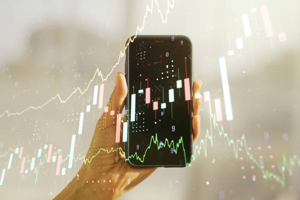 istock Abstract creative financial graph and hand with mobile phone on background, financial and trading concept. Multiexposure 1366412201