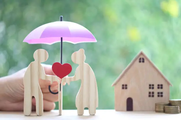 Mutual fund,Love couple senior holding heart shape and hand holding the umbrella with model house on natural green background, Save money for prepare in future and pension retirement concept