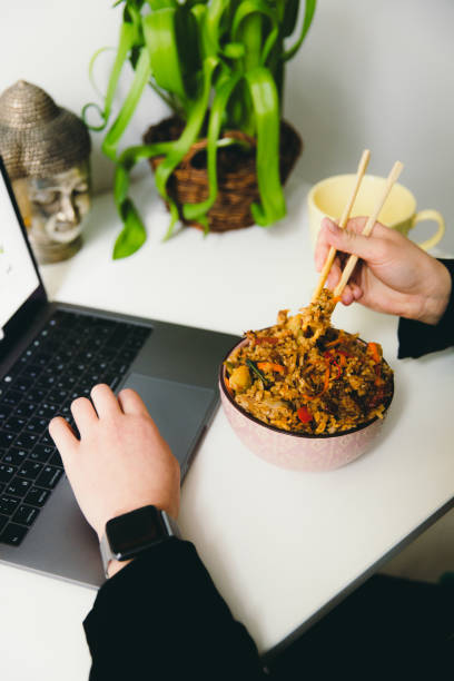 istock Female having dinner with Asian friend rice with seafoodl while studying at home 1366414894