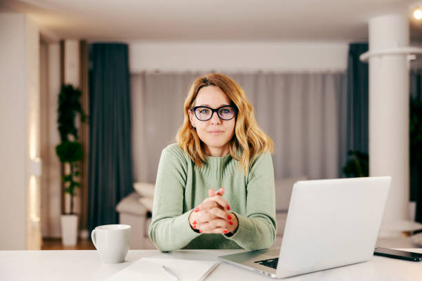 istock A middle-aged woman working online from her comfortable home and looking at the camera. 1366416936