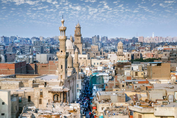 vista aérea de la calle al-muizz del cairo islámico con mezquitas, palacios y edificios residenciales desde el minarete de la mezquita-madrasa del sultán al-ghuri, el cairo, egipto. - cairo egypt mosque minaret fotografías e imágenes de stock