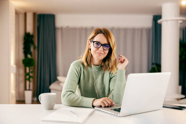 uma empresária feliz trabalhando online de sua casa aconchegante no laptop. - enterprise digital assistant - fotografias e filmes do acervo