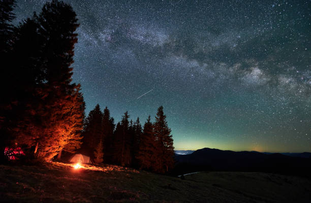 istock Mountain hills with snow-capped peaks under starry sky. 1366419149