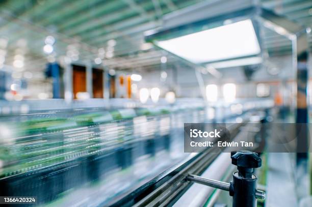 Motion Blurred Fast Moving Water Bottles At Mineral Water Factory Production Line At Finishing Line In A Row Moving Queuing For Labelling Packing Stock Photo - Download Image Now
