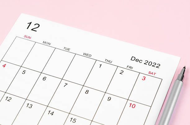 istock December 2022 calendar sheet with pen on pink background. 1366423666