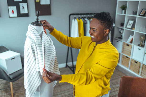 istock Tailor adjusts garment design on mannequin in workshop 1366424699