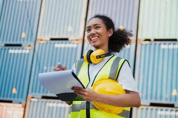 istock Businesswoman, foreman holding clipboard with container ship background 1366424898