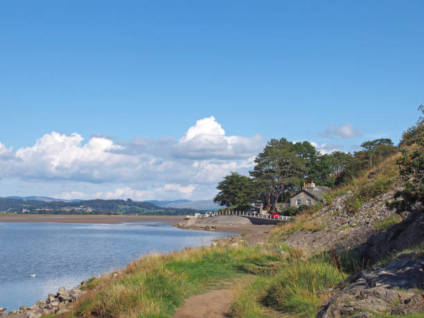 widok na domy wzdłuż drogi wzdłuż wybrzeża w arnside w kumbrii z otaczającymi wzgórzami pojezierza w lecie - morecombe bay zdjęcia i obrazy z banku zdjęć