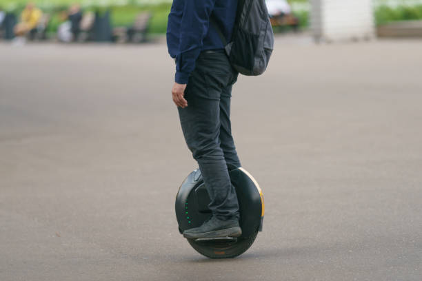 young man driving electric unicycle on the moscow city street - unicycle men young adult standing imagens e fotografias de stock