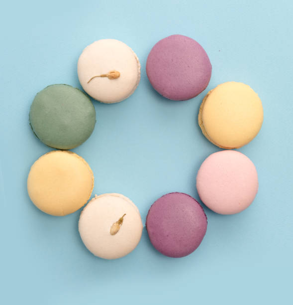 Sweet colorful macaroons on blue table background.