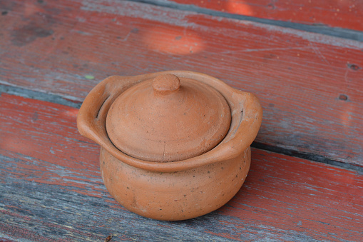 Top view of clay short pot is on the table in pottery situated on wooden table.