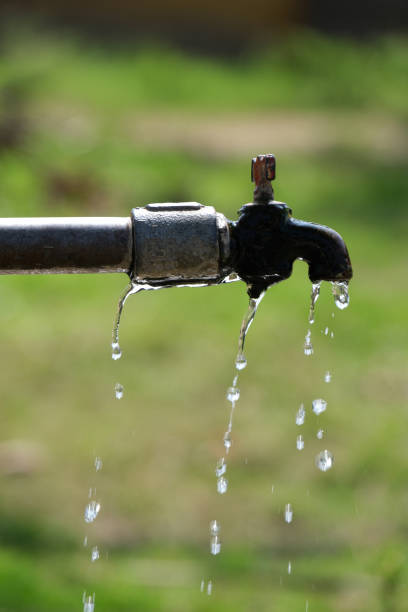 água vaza da torneira de água metálica na porta, foco seletivo. - valve water pipe leaking faucet - fotografias e filmes do acervo