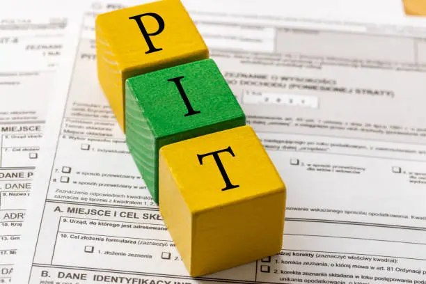 Photo of Annual tax settlement in Poland, Form for private persons, Wooden blocks with the word PIT