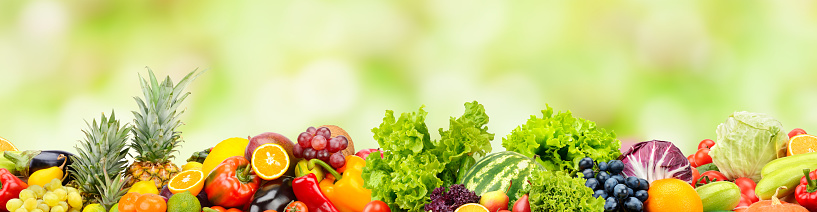 Fresh fruits, vegetables, berries on green background. Seamless horizontal pattern.