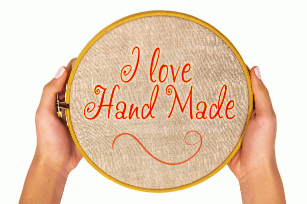 Embroidery hoop with natural linen fabric in women's hands, isolate. Template with text - I love Hand Made. Flat top view.