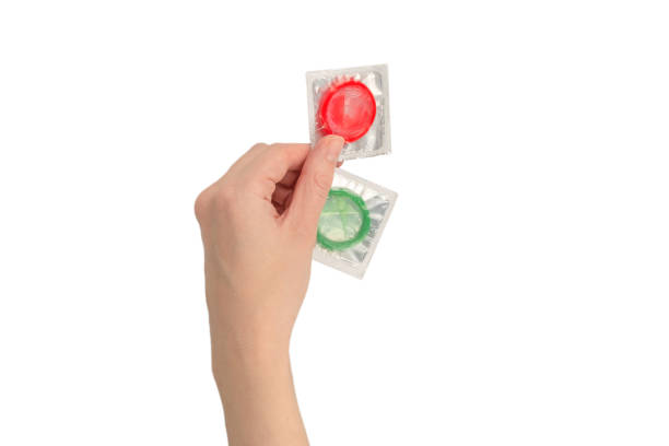 istock Condom in woman hand isolated on white background. 1366440237
