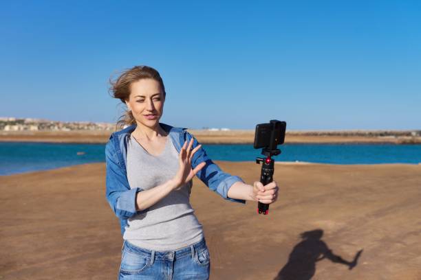 istock Mature woman recording video on smartphone, making a stream 1366440505
