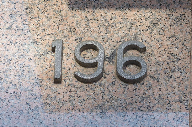 istock House number one hundred and ninety-six on a marble wall. 1366441893