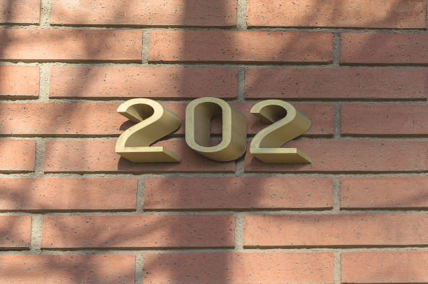 istock Enameled house number two hundred and two on a brick wall. 1366441900